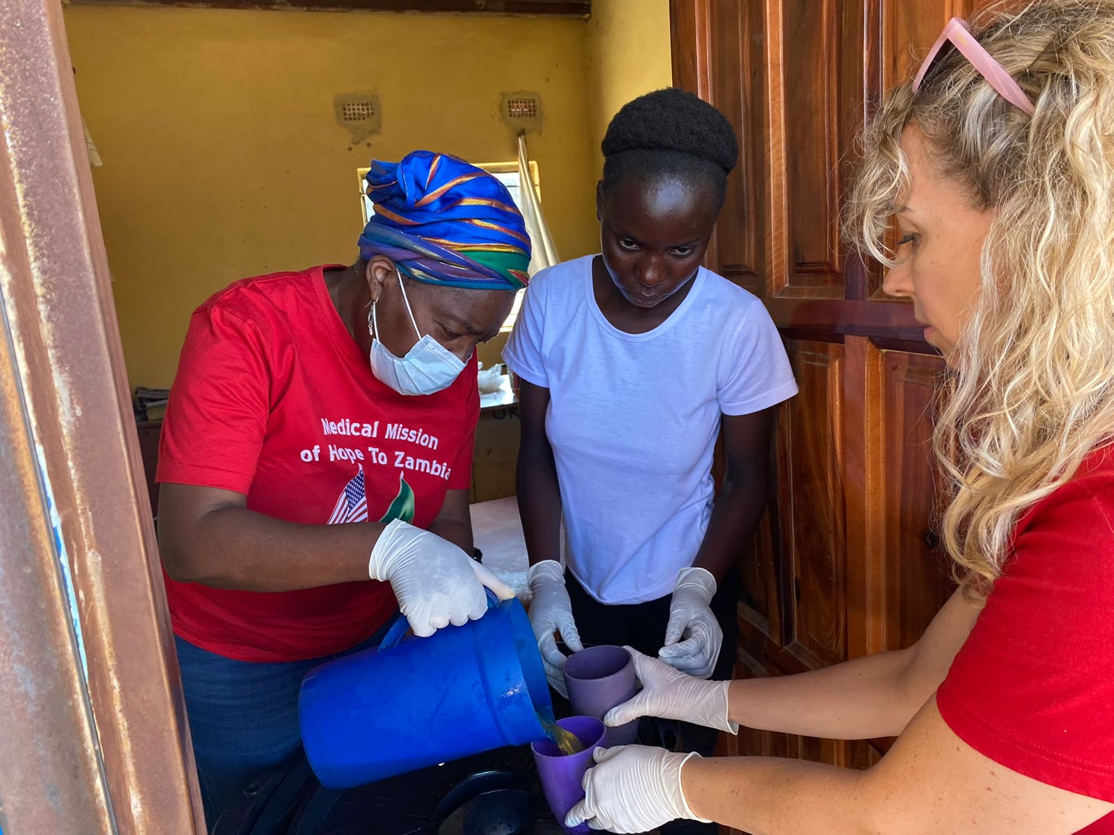 Volunteers in gloves and masks handing out medicine