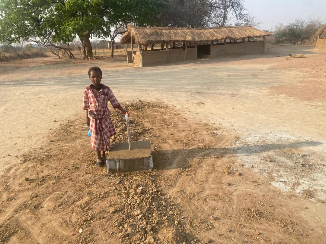 A girl at a new water tap in Chibenge Shibuyunji