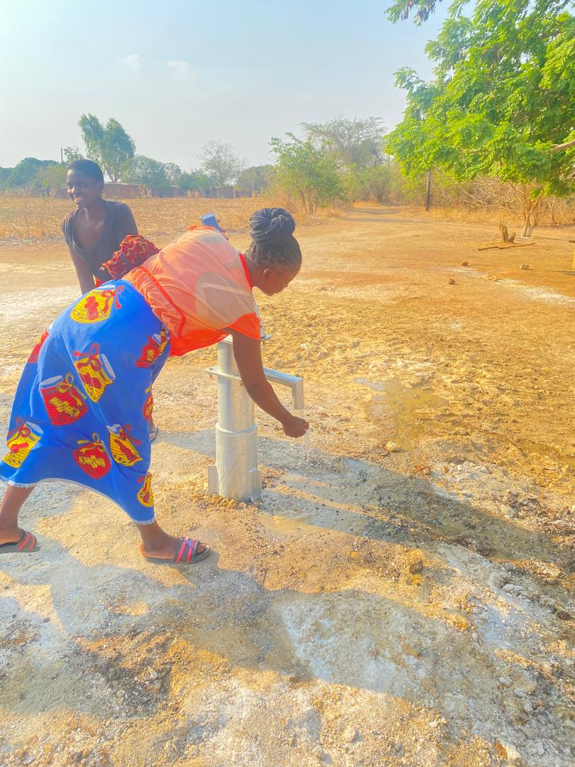 Women accessing water from hand pump well